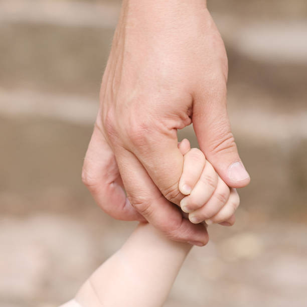 istock father's hand lead his child son 178532865