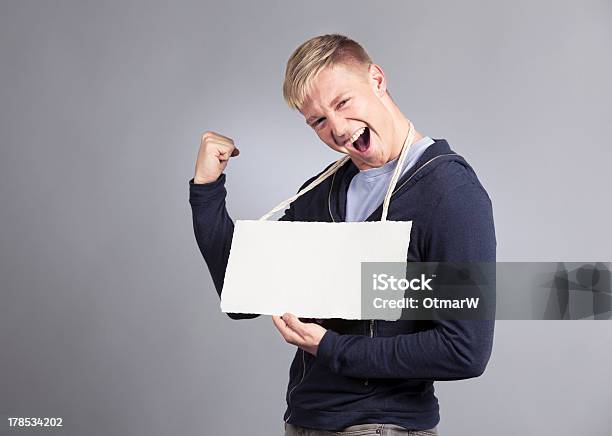 Overjoyed Hombre Presenta Vacío Signboard Foto de stock y más banco de imágenes de Adulto - Adulto, Adulto joven, Agarrar