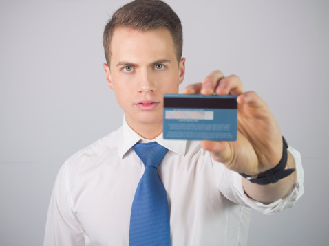 Young attractive businessman holding credit card.