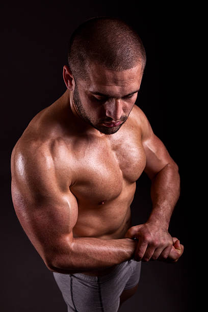 istock Muscular man showing muscles isolated on black background 178535406
