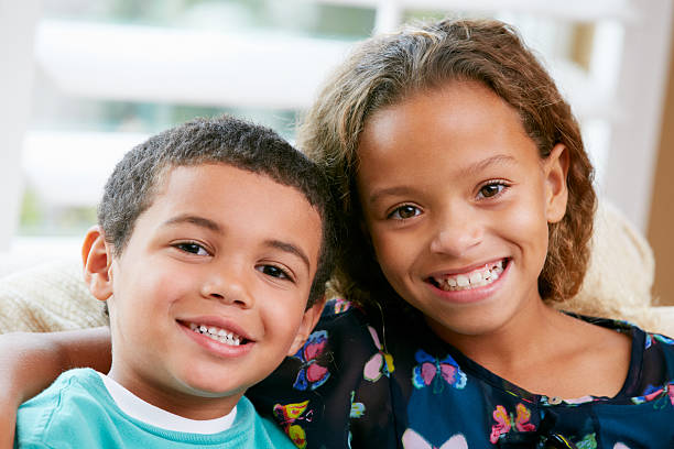 istock Two young siblings sitting on a couch and hugging 178535614