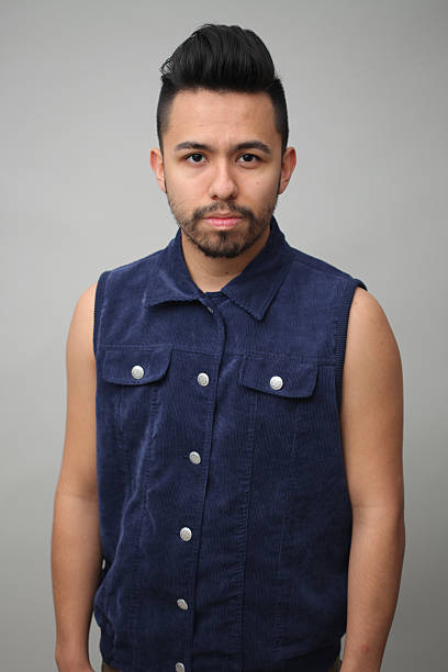 Serious hispanic male portrait in the studio Young handsome male adult staring at the camera in the studio. Hes wearing a corduroy blue vest high school photos stock pictures, royalty-free photos & images