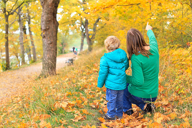 famiglia a piedi in autunno - moving up child pointing looking foto e immagini stock