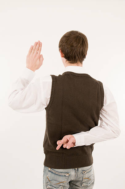 man take an oath cross ones fingers back Waist up a young man in the white shirt and Brown Westover from behind against white background made the oath the left hand and the right hand with crossed fingers behind his back holding speaking with forked tongue stock pictures, royalty-free photos & images