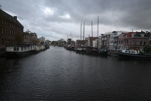 A scenic view of a canal lined with several boats and buildings. Leiden, Netherlands