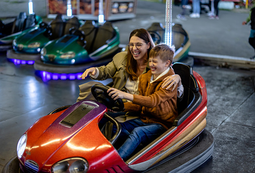 In the realm of bumper cars, a parent and their child build unbreakable bonds, sharing laughter and thrilling moments that strengthen their connection at the amusement park