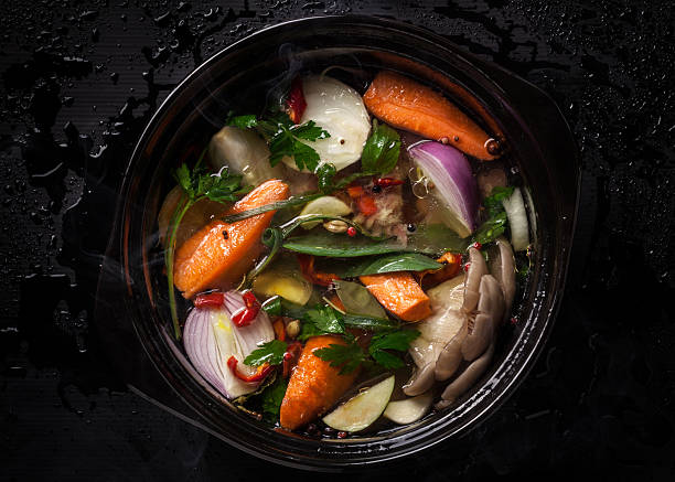 Cтоковое фото Uncooked Овощной суп в керамическая посуда на черном фоне