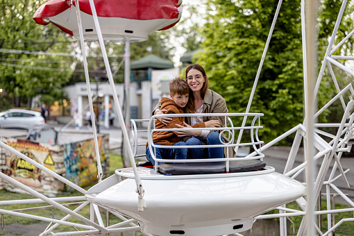 Fascinated and captivated, a mother and her son find sheer delight on the whirling merry-go-round, cherishing the magical moments they experience together