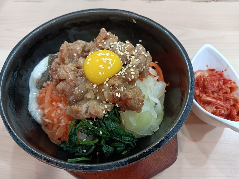 Popular Korean dish with rice fried hot inside stone bowl, served with meat and miscellaneous sauercraft