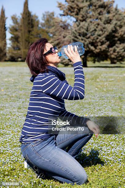 Mitte Alter Frau Entspannend Und Trinkwasser Auf Gras Stockfoto und mehr Bilder von 40-44 Jahre