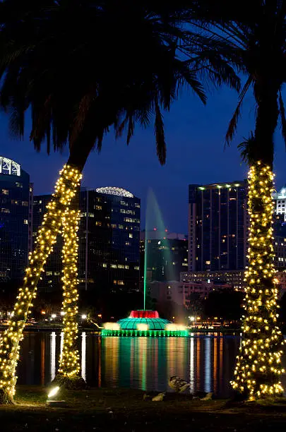 Orlando skyline at twilight during the Christmas holidays. Lake Eola and fountain in foreground.