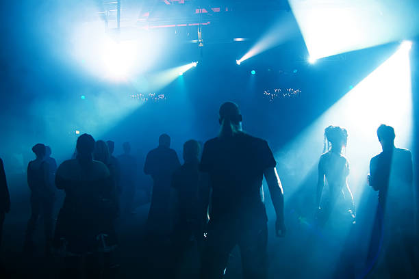 istock Silhouettes of crowd inside club illuminated by blue lights 178539002