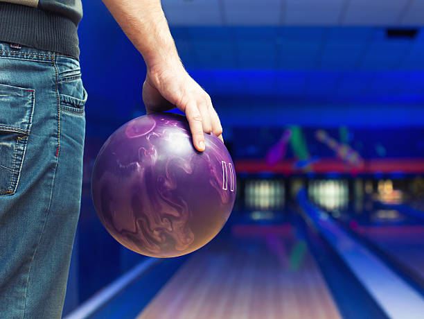 Man with bowling ball Man holding ball against bowling alley ten pin bowling stock pictures, royalty-free photos & images
