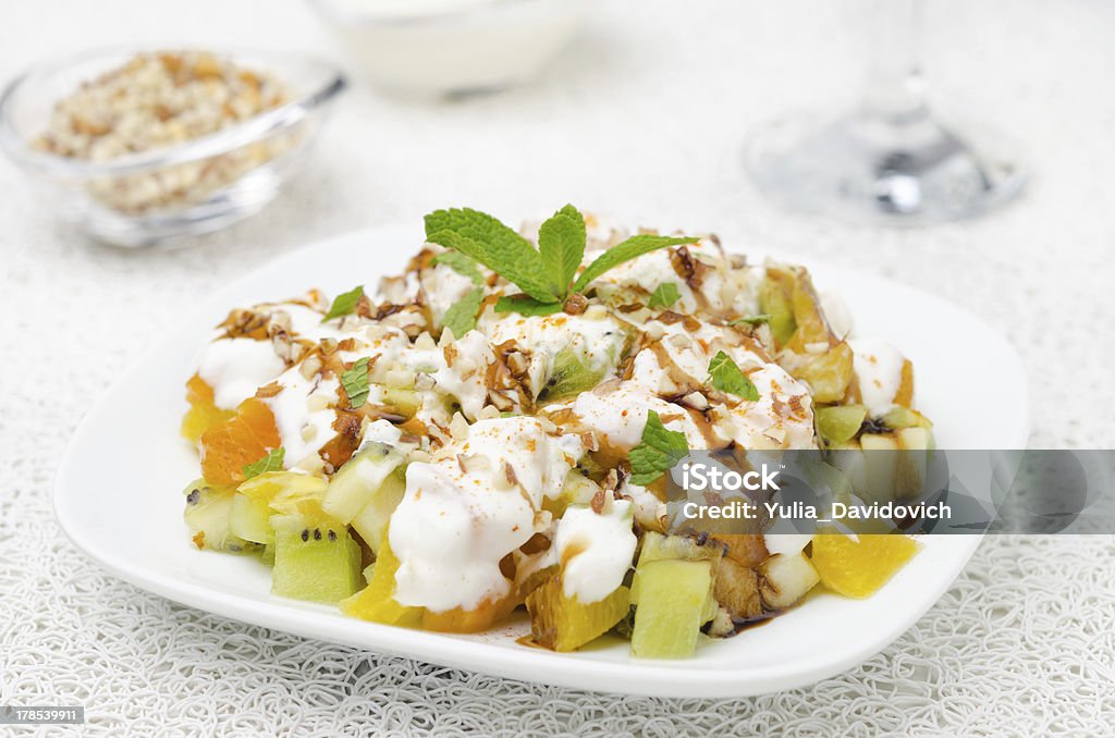 fruit salad with nuts, yogurt and mint "fruit salad with nuts, yogurt and mint garnished with yogurt and nuts, closeup" Appetizer Stock Photo