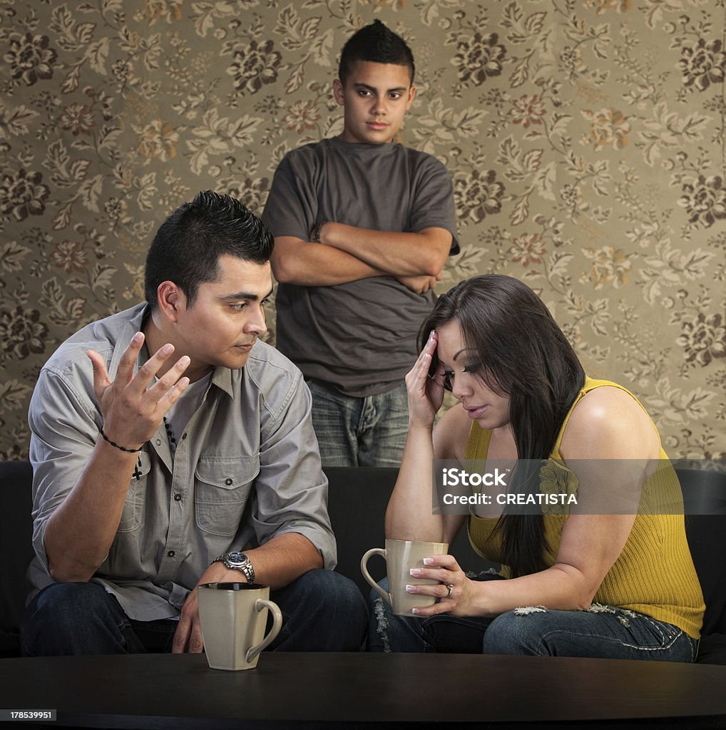 Worried Parents With Angry Son Worried Native American couple with upset son indoors Indigenous Peoples of the Americas Stock Photo