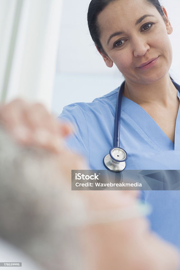 Sonriente enfermera mirando a un paciente - Foto de stock de 30-39 años libre de derechos