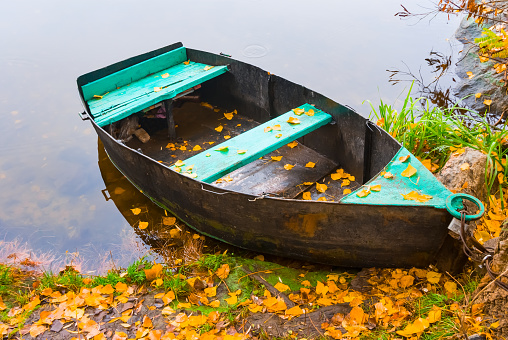 closeup oar boat stay near a coast, autumn river scene