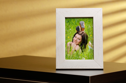 Girls portrait in a photo frame, standing on a table