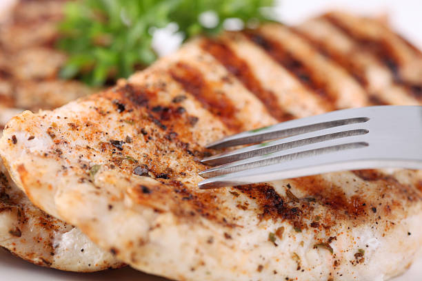 Grilled chicken breasts on a plate with fresh vegetables stock photo