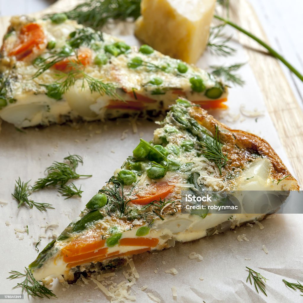 omelet Wedges of vegetable frittata on a board, with parmesan and dill. Asparagus Stock Photo