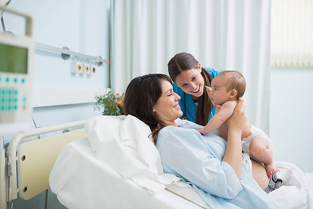 mediziner mit mutter holding baby boy in windel - humor mother 20s adult stock-fotos und bilder