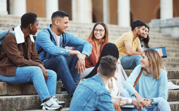 istock Laughing students, bonding or university stairs on college campus for group study, diversity class break or open day social. Smile, happy or talking friends, education learning goals on school steps 1785442620