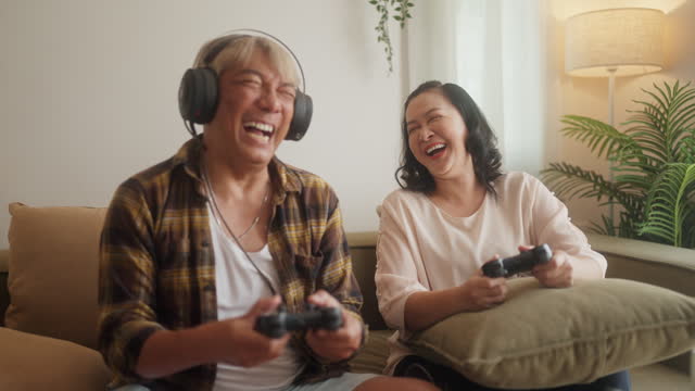 Senior Couple Embraces Joyful Gaming in Living Space.