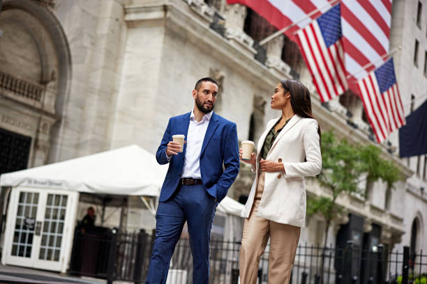Wall Street workers walking outdoors with coffee