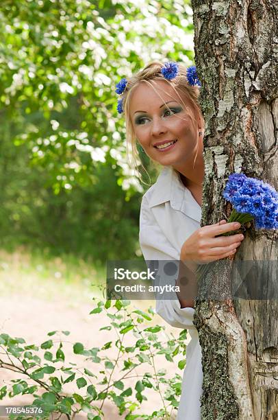 Mulher Olhar Para Fora Atrás De Uma Árvore - Fotografias de stock e mais imagens de Adulto - Adulto, Ao Ar Livre, Azul