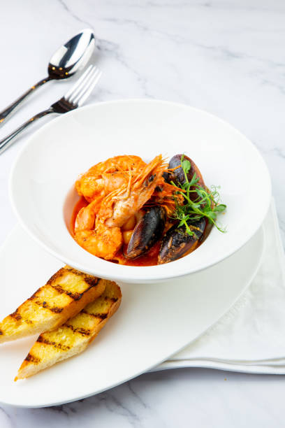 istock shrimp and mussels with herbs in a white plate with toasted bread, side view 1785455327