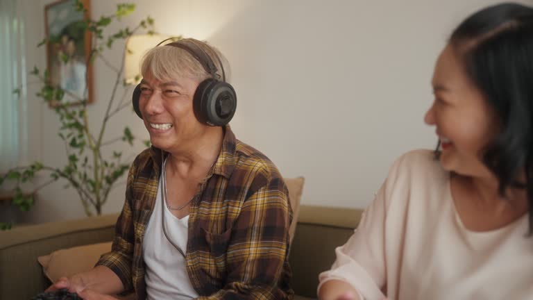 Senior Couple Embraces Joyful Gaming in Living Space.