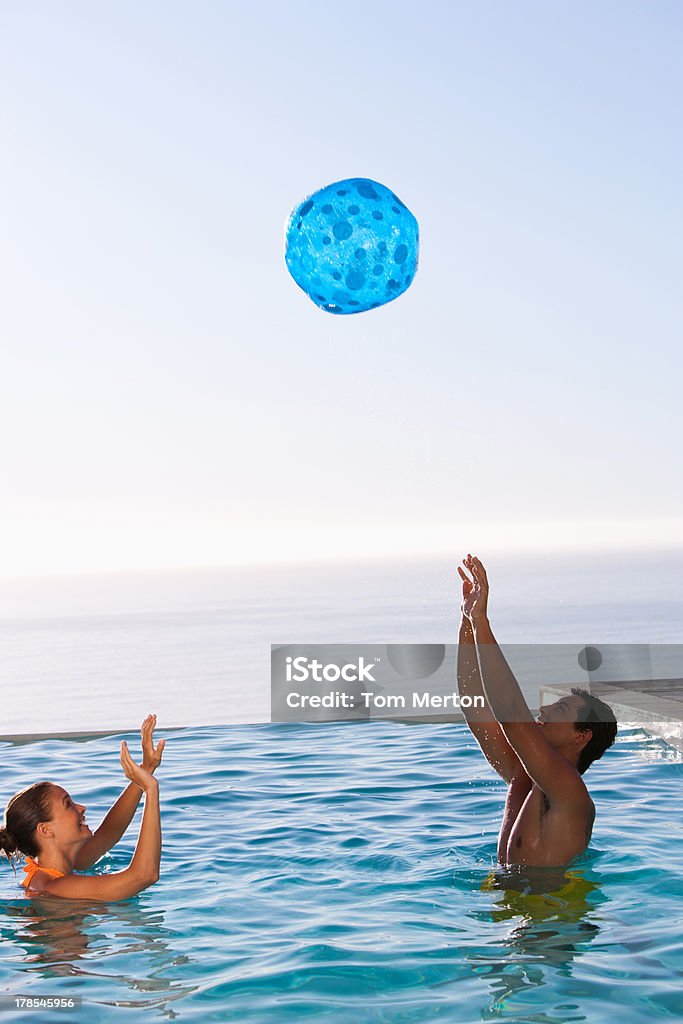 Homem e mulher brincando com a bola na piscina - Royalty-free 20-24 Anos Foto de stock