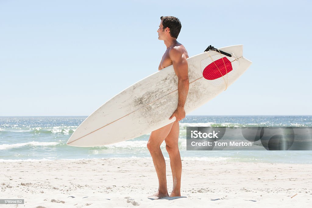 Hombre con tabla de surf en la playa - Foto de stock de 30-39 años libre de derechos