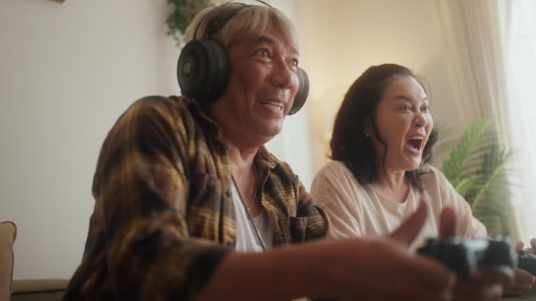 Senior Couple Embraces Joyful Gaming in Living Space.