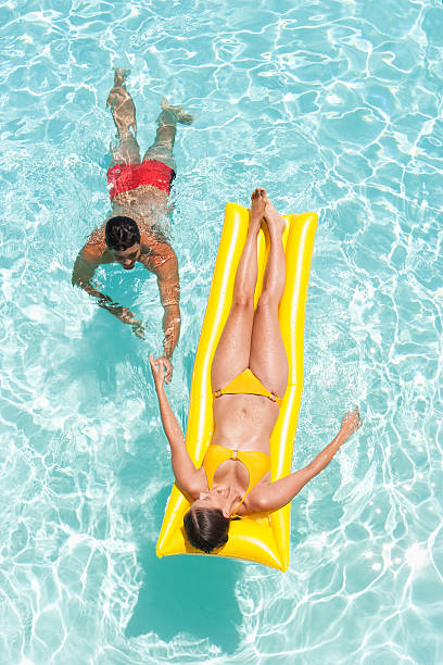 hombre y mujer en la piscina - swimming trunks bikini swimwear red fotografías e imágenes de stock