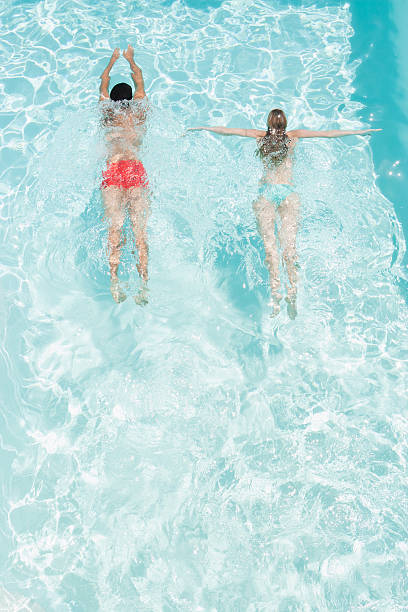 hombre y mujer en la piscina - swimming trunks bikini swimwear red fotografías e imágenes de stock