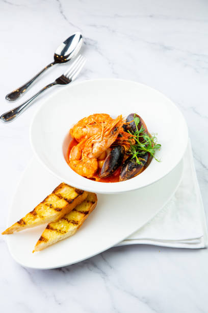 istock shrimp and mussels with herbs in a white plate with toasted bread, side view 1785464306