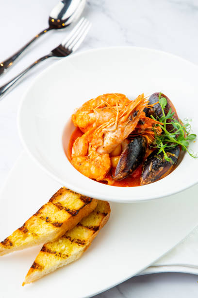 istock shrimp and mussels with herbs in a white plate with toasted bread, side view 1785476616