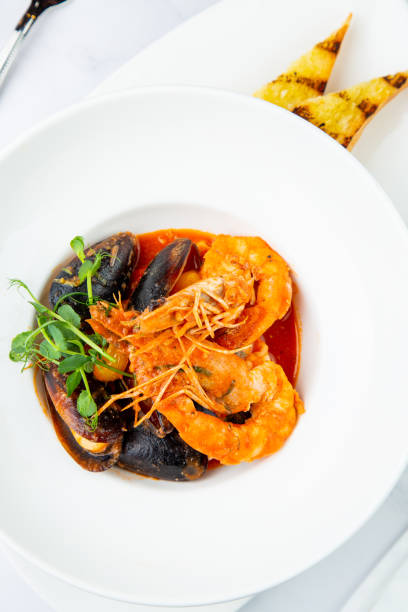 istock shrimp and mussels with herbs in a white plate with toasted bread, side view 1785481031