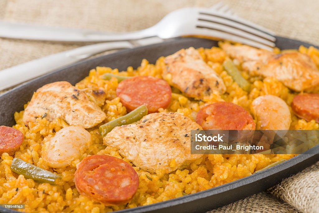 Valencian Paella Traditional Valencian paella with white rice, chicken, sausage, butter beans and green vegetables. Chicken Meat Stock Photo