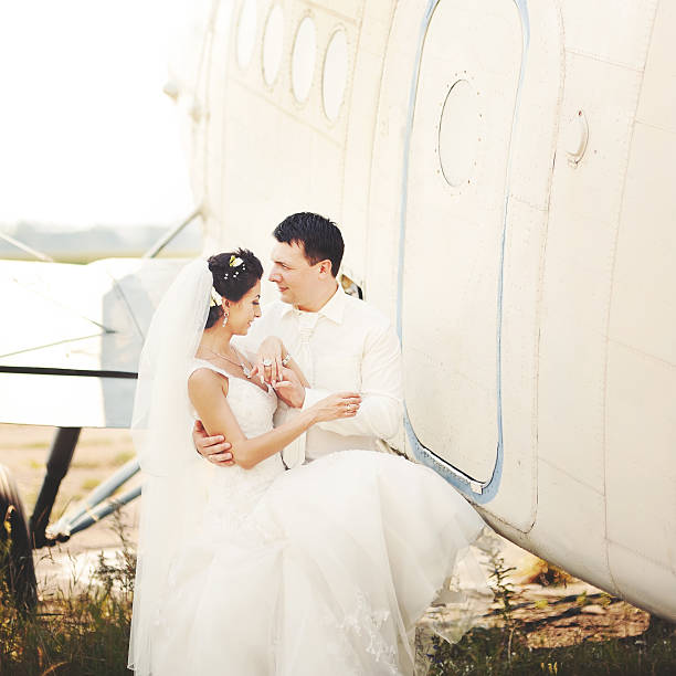 istock young caucasian wedding couple next to airplane 178548329