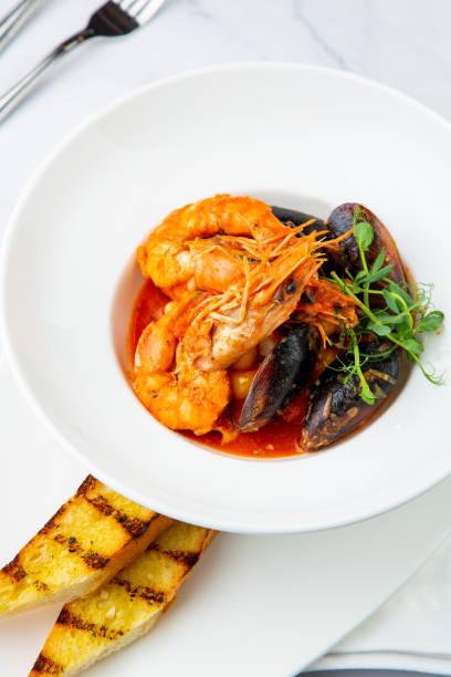 istock shrimp and mussels with herbs in a white plate with toasted bread, side view 1785483508