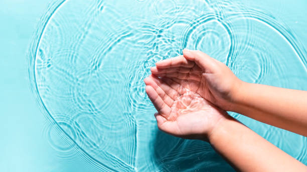 istock Woman washing cleaning hands by both two hands purity transparent water blue background copy space. People lifestyle hygiene medical nature protective wellness. World environment day World water day 1785486430