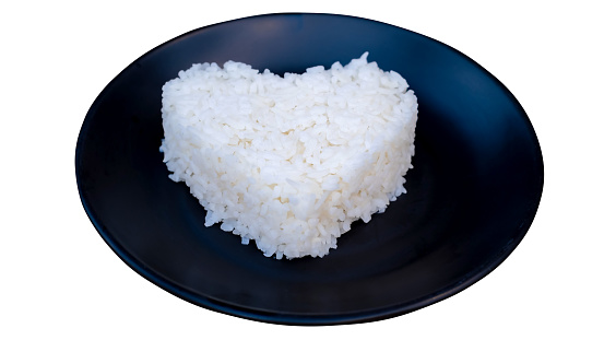 Jasmine rice with heart shape on black plate isolate on white background with clipping path,
