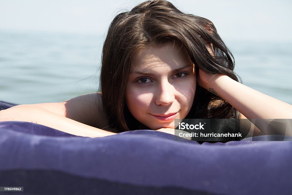 Fille bronzer sur le matelas d'air en mer - Photo de Activité de loisirs libre de droits