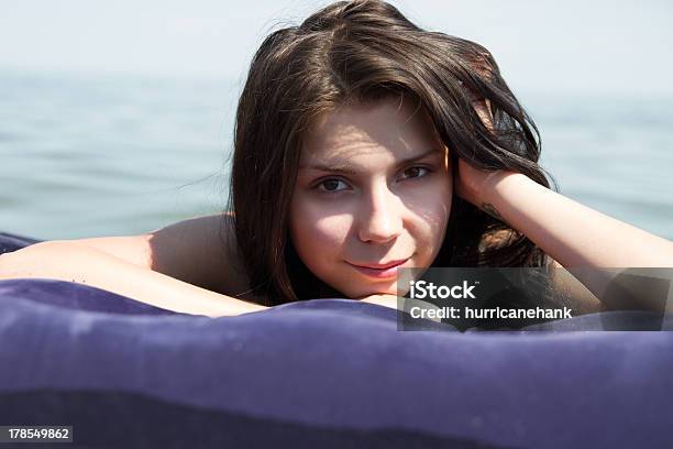 Foto de Menina Tomando Banho De Sol Com Colchão De Ar Na Mar e mais fotos de stock de Adolescente