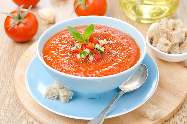 Bowl of cold tomato gazpacho soup with basil and croutons