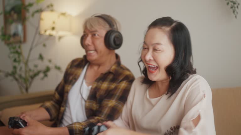 Senior Couple Embraces Joyful Gaming in Living Space.