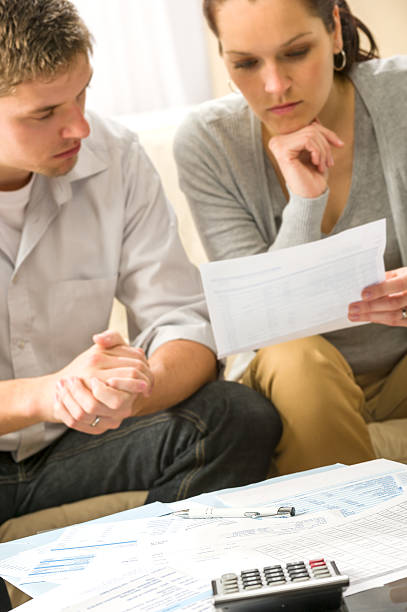 istock Troubled couple calculating finances 178550783