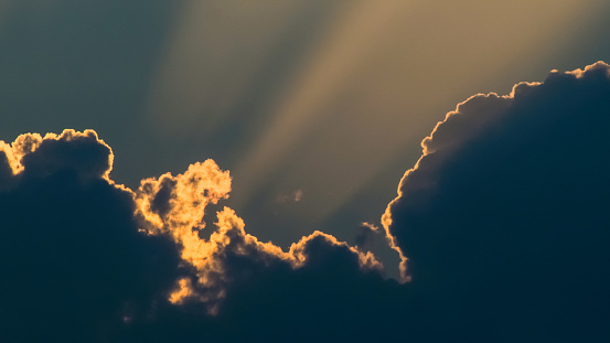 Vue rapprochée de silhouettes de cumulonimbus, illuminées par une lumière orangée, pendant le crépuscule